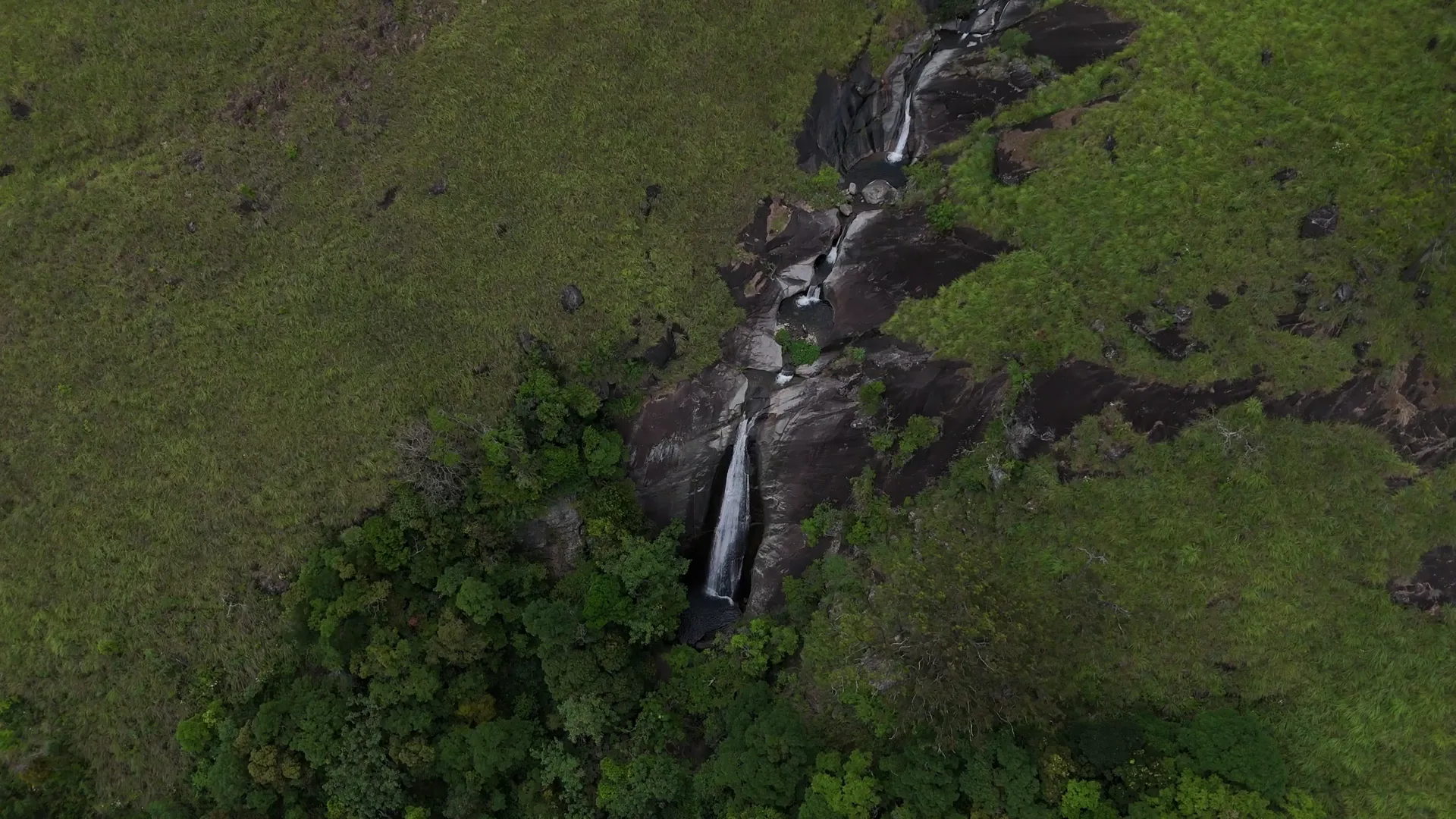 Overhead aerial glide over lush mountain waterfall at Bakers Reserve Nonpareil